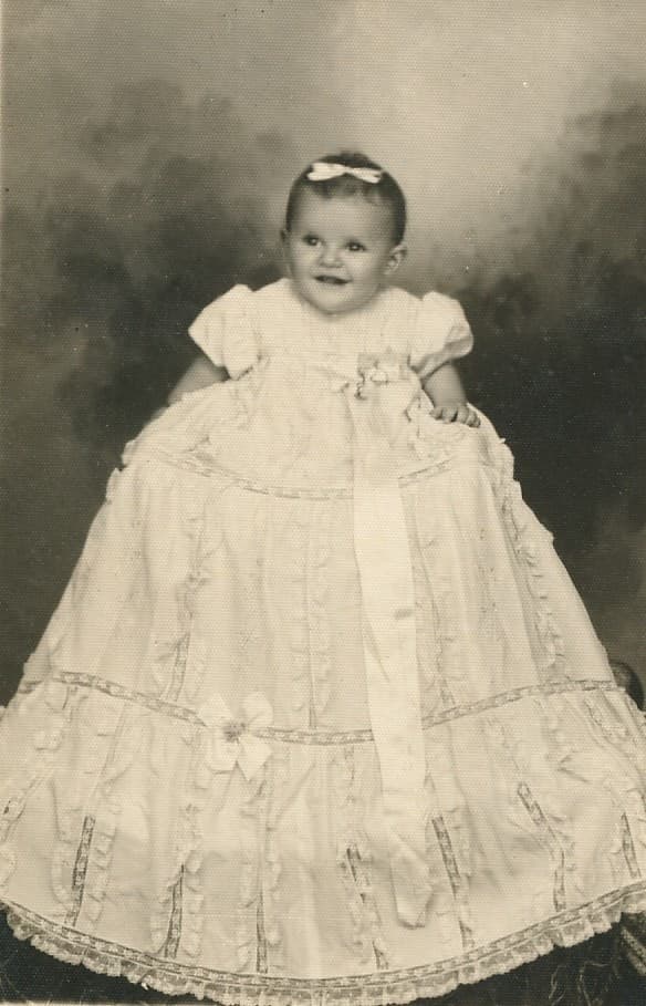 Foto antiga de batizado em sépia - bebê com vestido tradicional